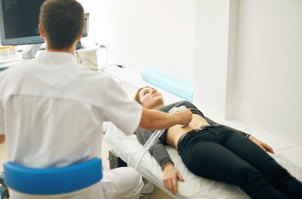 Young,Doctor,Testing,The,New,Ultrasound,Machine.,Back,View,Photo.